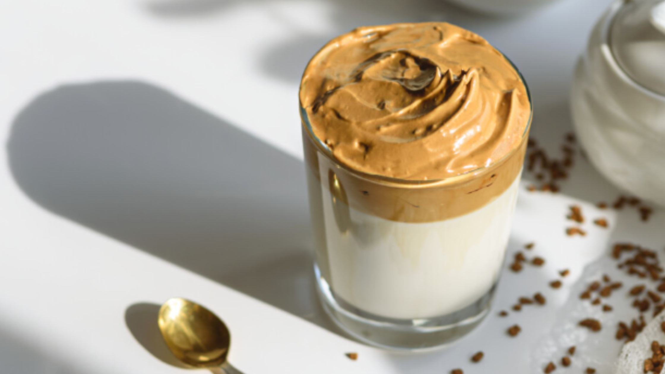 Café Dalgona servido em copo transparente com leite e creme de café por cima