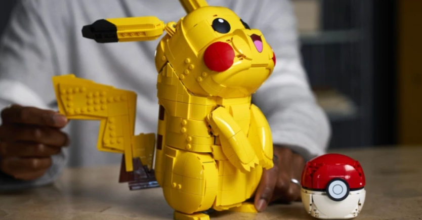 Pokémon montado em LEGO sobre a mesa, com peças coloridas visíveis, representando um momento de criação e nostalgia